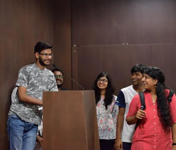 Students at a lectern asking questions during a session