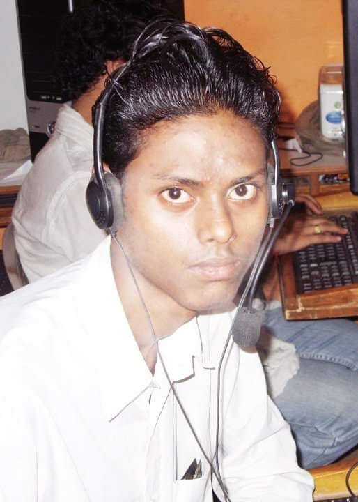 Santosh Pyasa at a desk in a computer lab, wearing a headset